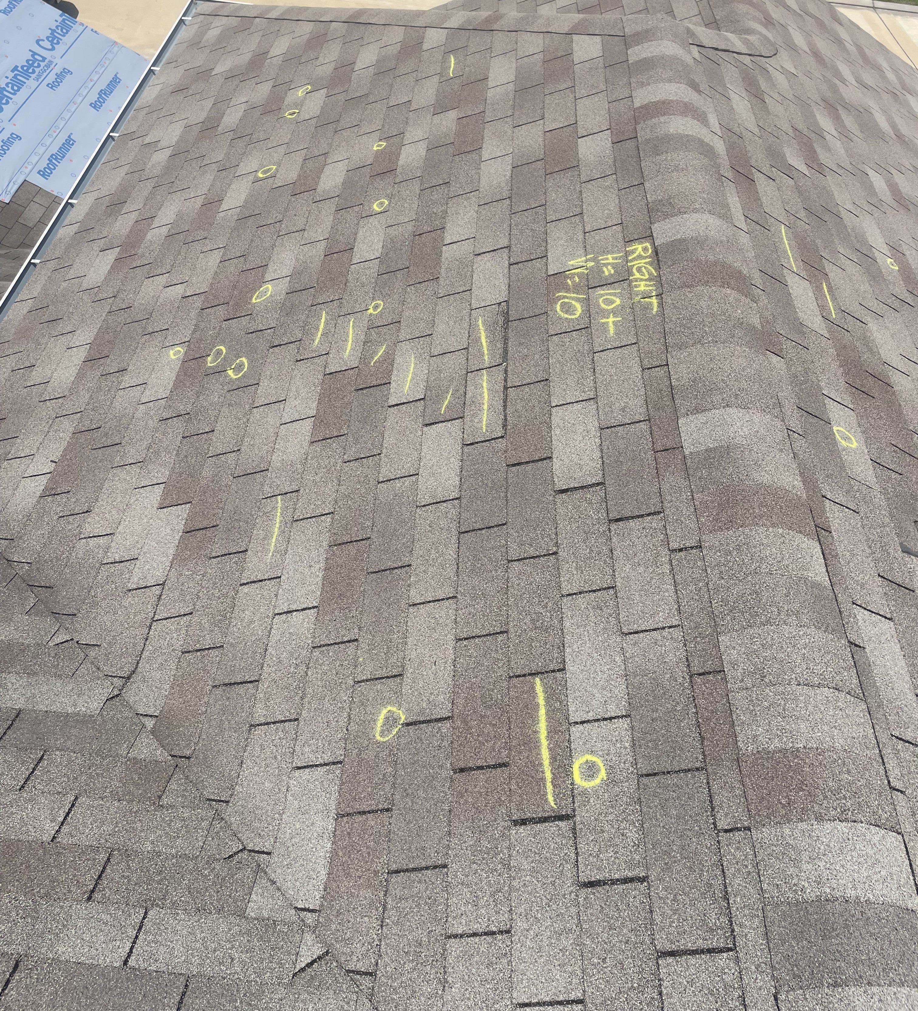 Roof shingles with marked storm damage points documented during an adjuster meeting.
