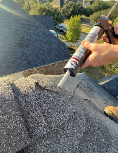 Roofing technician applying sealant to exposed nail heads and shingles during a professional roof tune-up service
