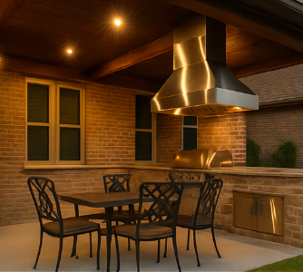Covered outdoor kitchen with a stainless steel grill, brick walls, and a dining table under patio lighting.