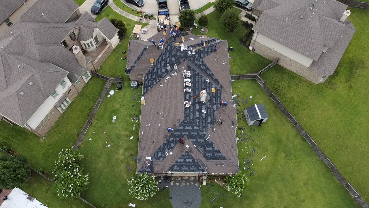 Aerial view of a residential roof replacement project performed by Prime Property Builders, showing materials and work areas during installation.