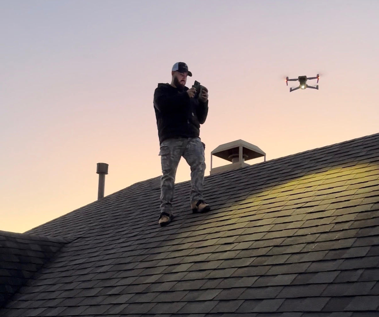 Roofing inspector using a drone to perform a professional roof inspection and document roof conditions from above.