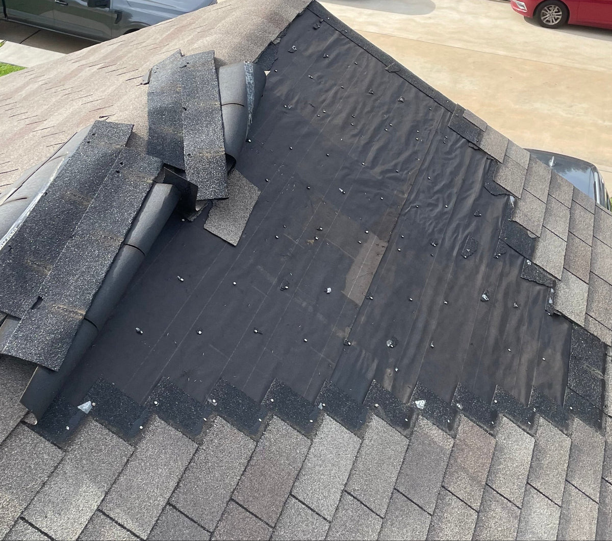 Damaged roof with missing shingles in Houston.