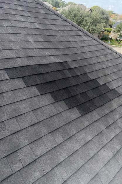 Asphalt shingle roof showing repaired section after professional roof repair service by Prime Property Builders