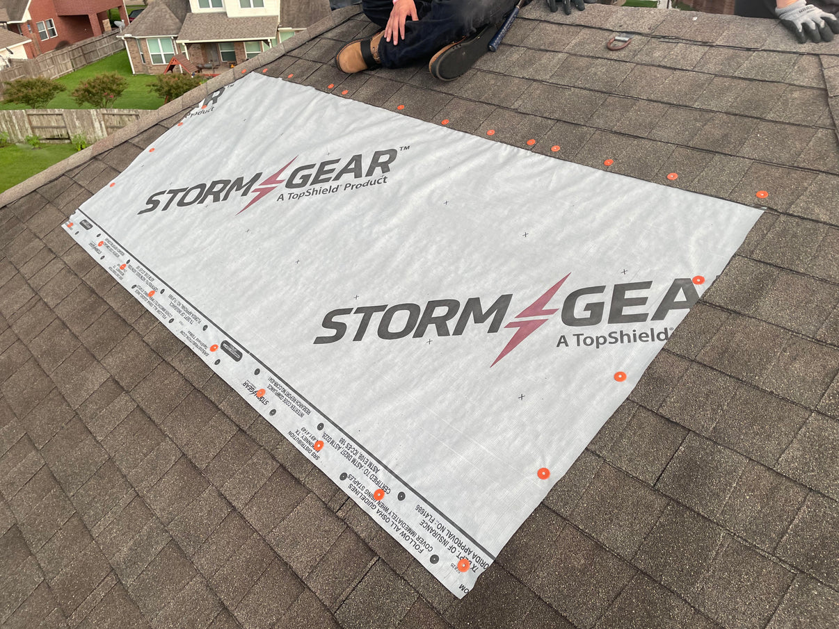 Heavy-duty storm tarp material installed on a roof to provide temporary leak protection