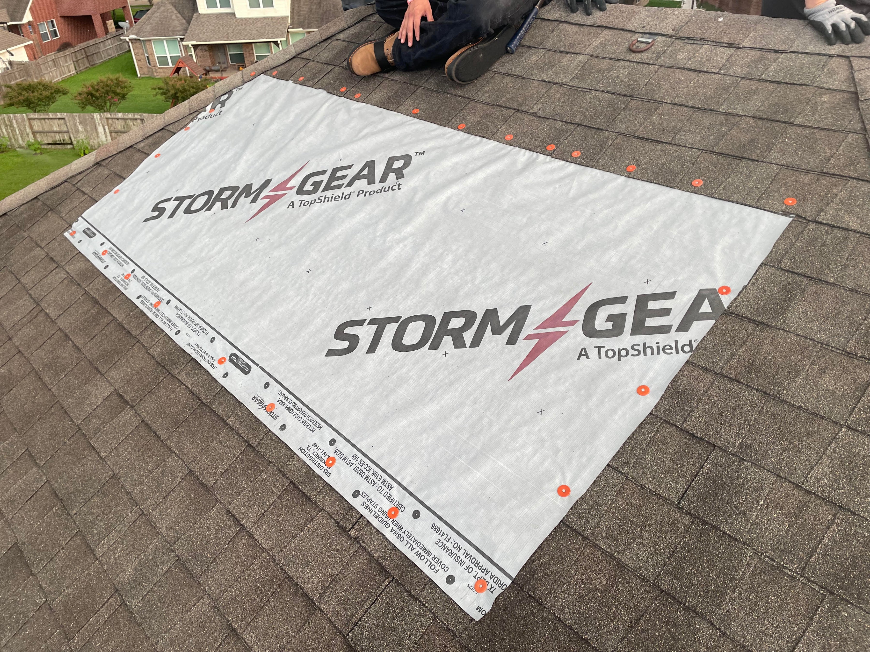 Heavy-duty storm tarp material installed on a roof to provide temporary leak protection
